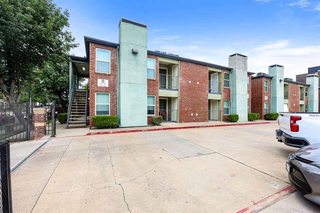 4622 Monarch Street, Unit 202 Dallas, TX 75204 - Photo 15 of 16 Exterior apartment building featuring red brick and light green stucco accents