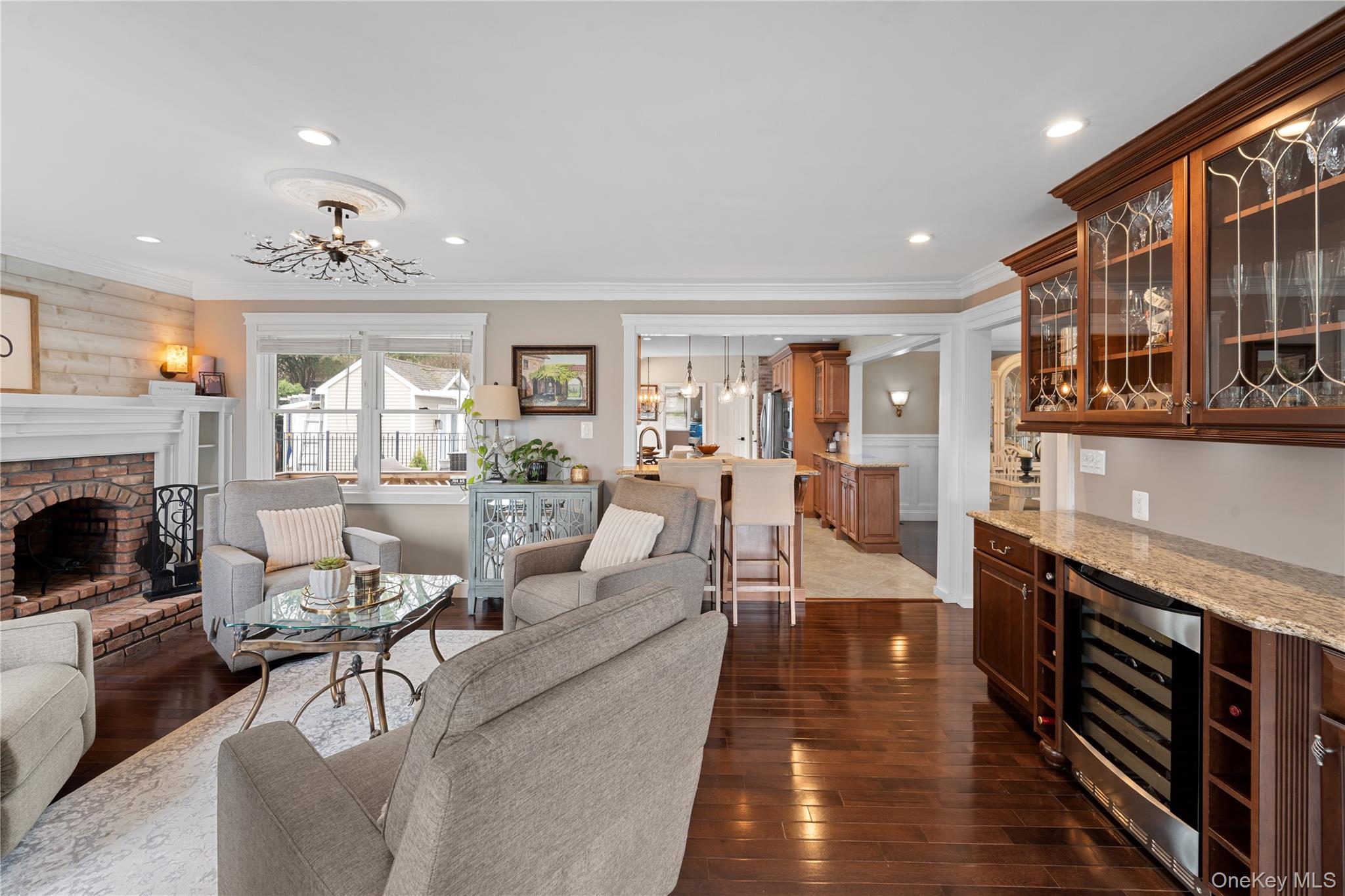 29 Dyke Road Setauket, NY 11733 - Photo 13 of 44 a living room with furniture a fireplace and a kitchen view