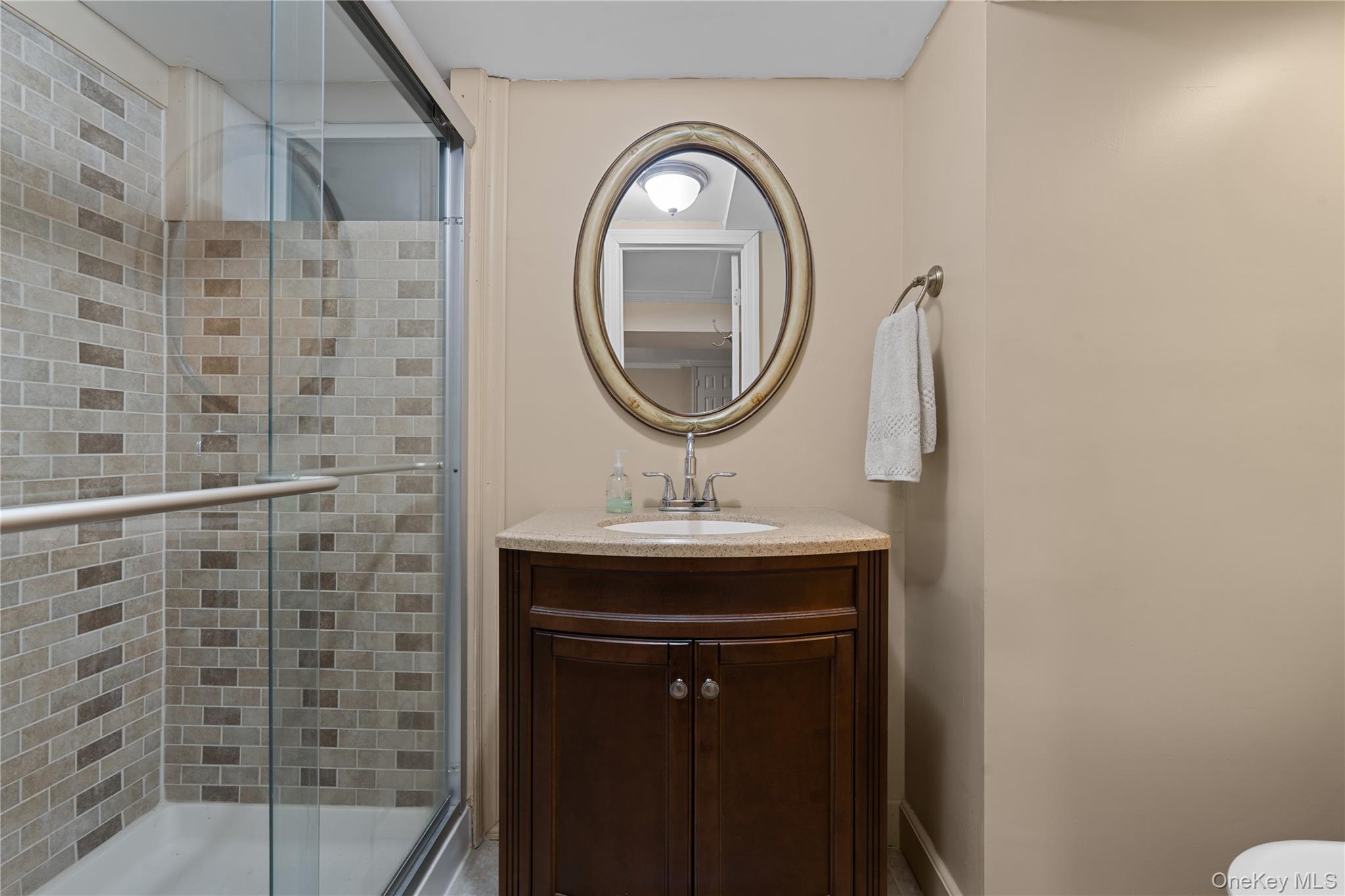 29 Dyke Road Setauket, NY 11733 - Photo 29 of 44 a bathroom with a sink a mirror and a shower