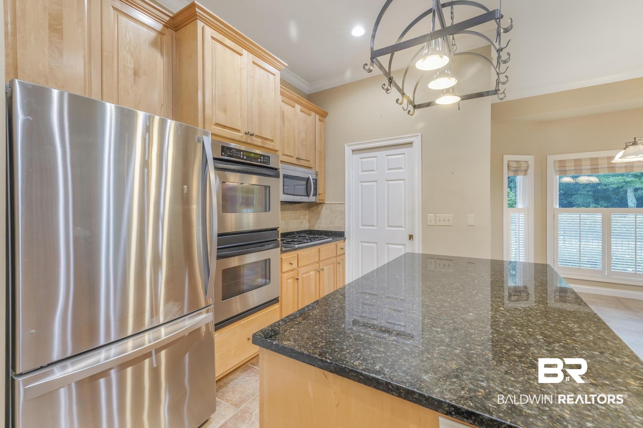13612 Rue Royal Lane Silverhill, AL 36576 - Photo 5 of 65 Kitchen with light brown cabinets, appliances with stainless steel finishes, backsplash, dark stone counters, and ornamental molding