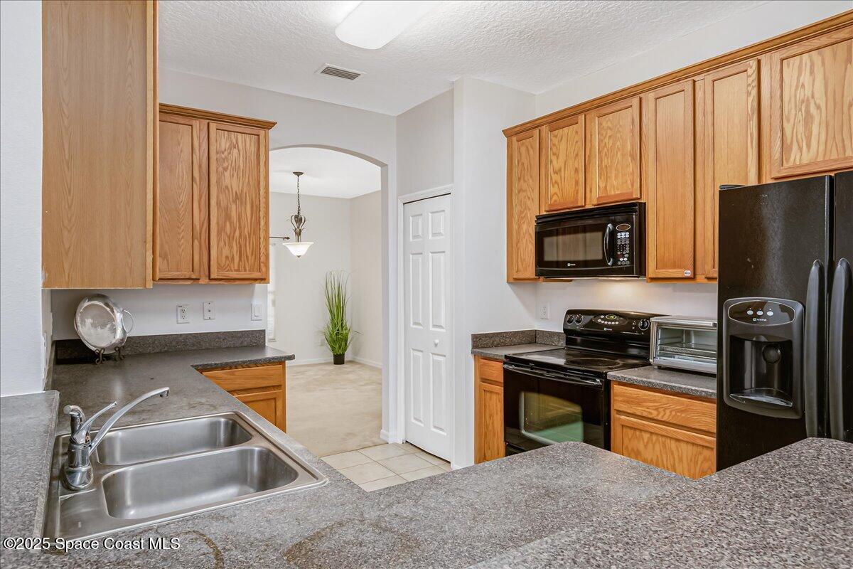 1062 Morgan Circle Northeast Palm Bay, FL 32905 - Photo 11 of 52 a kitchen that has a sink and a stove top oven