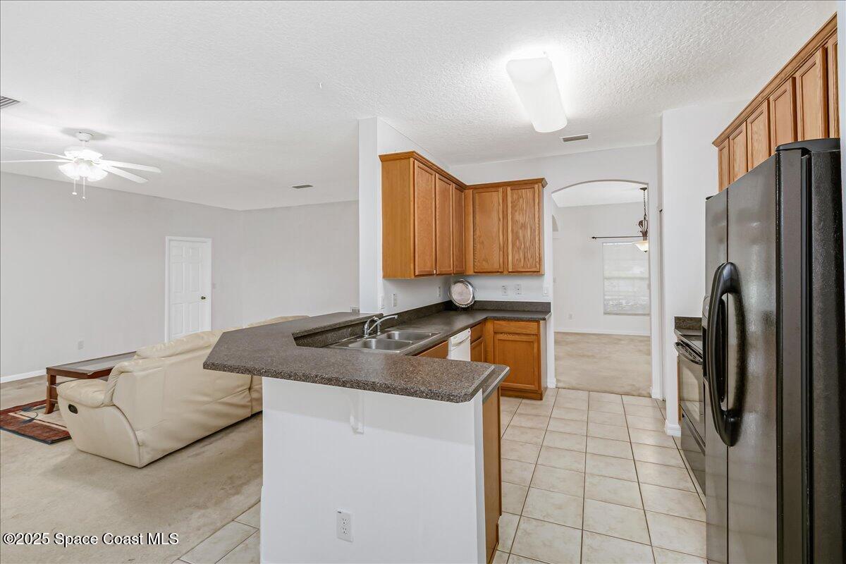 1062 Morgan Circle Northeast Palm Bay, FL 32905 - Photo 12 of 52 a kitchen with stainless steel appliances granite countertop a sink a refrigerator and a granite counter tops