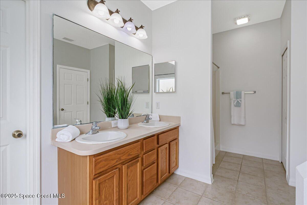 1062 Morgan Circle Northeast Palm Bay, FL 32905 - Photo 20 of 52 a bathroom with a double vanity sink and a mirror