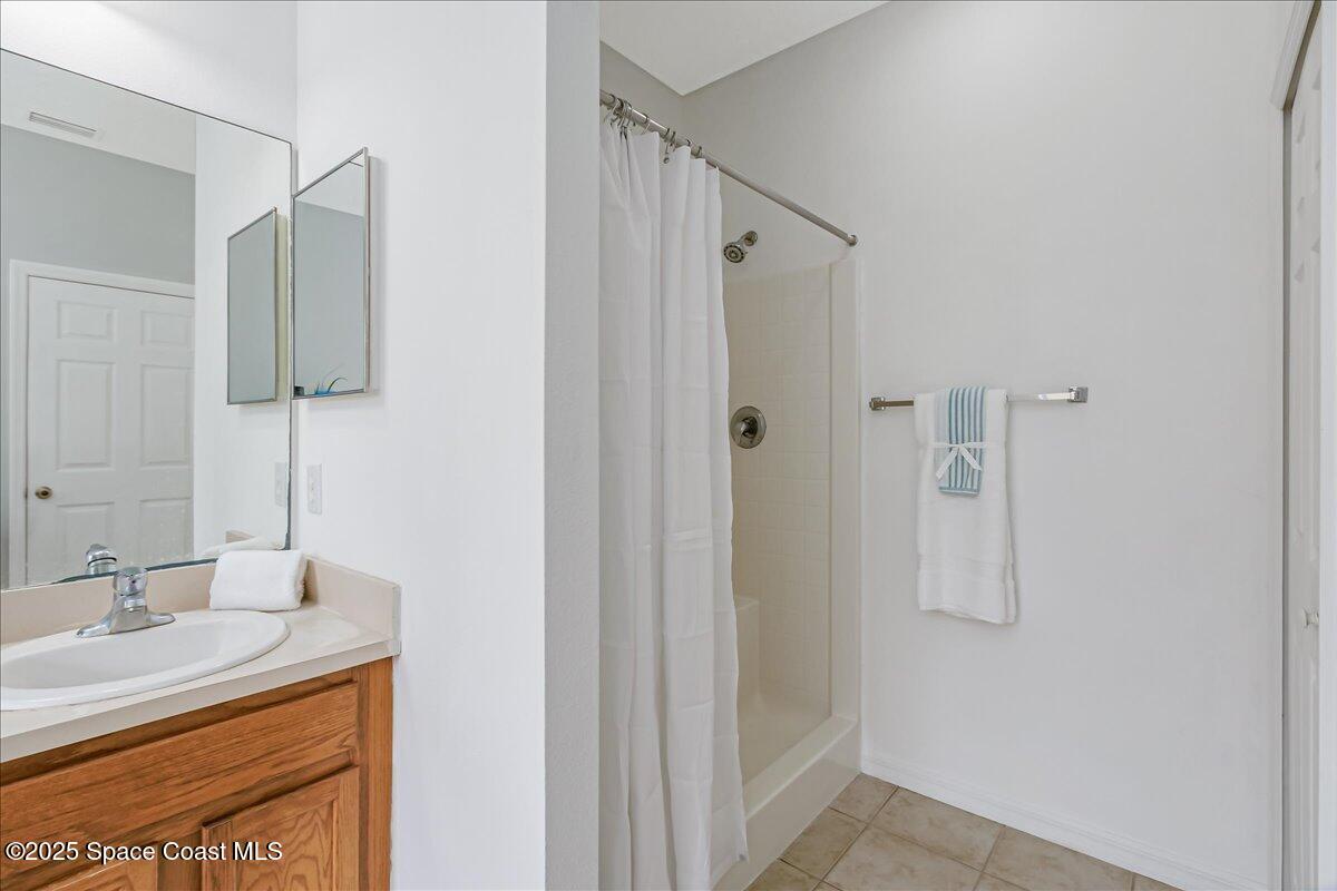 1062 Morgan Circle Northeast Palm Bay, FL 32905 - Photo 21 of 52 a bathroom with a granite countertop shower sink vanity and mirror