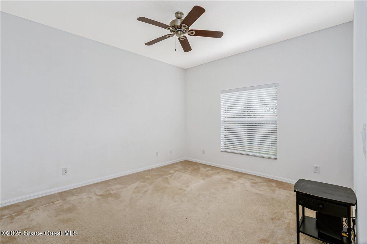 1062 Morgan Circle Northeast Palm Bay, FL 32905 - Photo 23 of 52 an empty room with a window and a ceiling fan