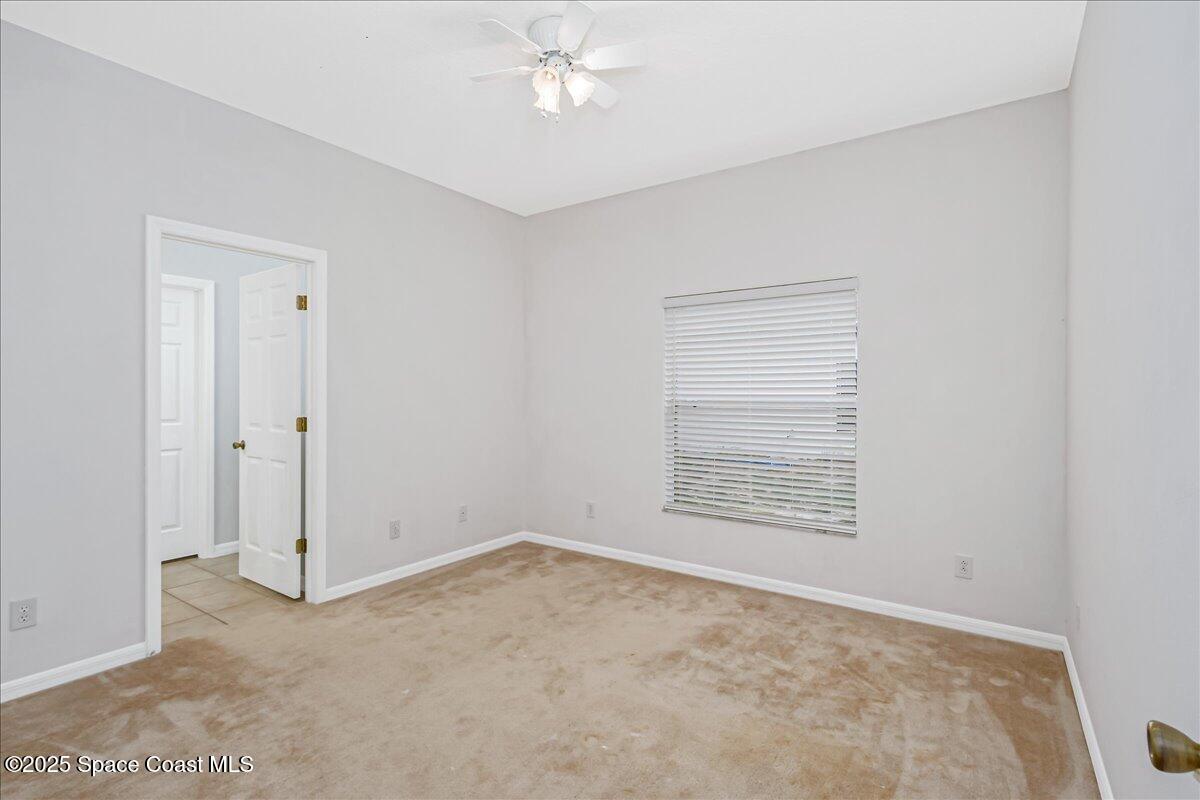 1062 Morgan Circle Northeast Palm Bay, FL 32905 - Photo 25 of 52 an empty room with a ceiling fan and a window