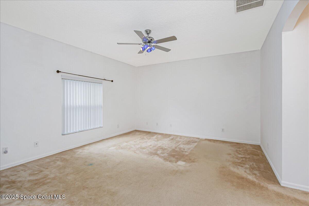 1062 Morgan Circle Northeast Palm Bay, FL 32905 - Photo 26 of 52 an empty room with a ceiling fan and a window