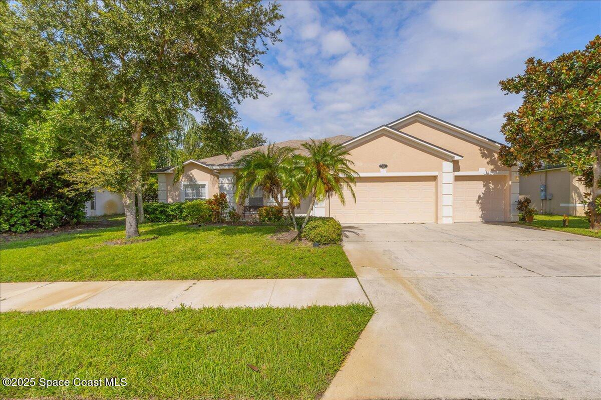 1062 Morgan Circle Northeast Palm Bay, FL 32905 - Photo 35 of 52 a view of house with garden and tall trees