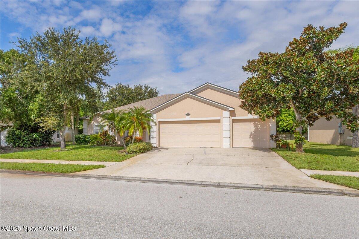1062 Morgan Circle Northeast Palm Bay, FL 32905 - Photo 37 of 52 a view of a house with a yard and large tree