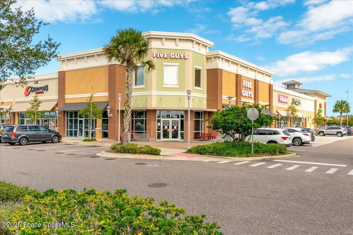 1062 Morgan Circle Northeast Palm Bay, FL 32905 - Photo 45 of 52 a front view of a building with street and trees