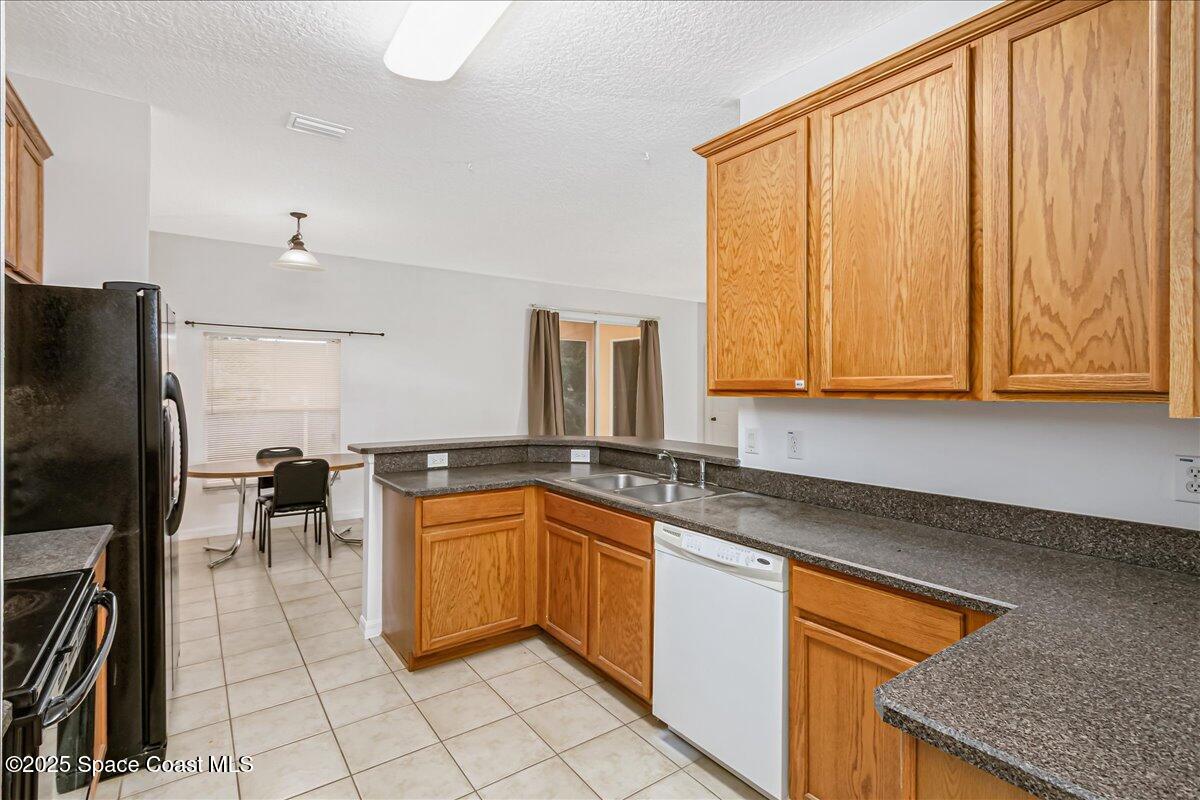 1062 Morgan Circle Northeast Palm Bay, FL 32905 - Photo 8 of 52 a kitchen with stainless steel appliances granite countertop a sink stove and cabinets