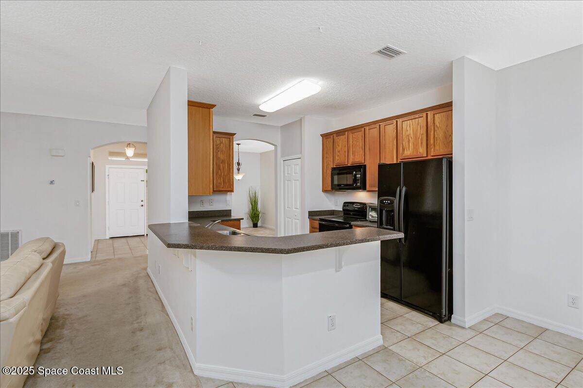 1062 Morgan Circle Northeast Palm Bay, FL 32905 - Photo 10 of 52 a kitchen with stainless steel appliances granite countertop a sink a stove and a refrigerator