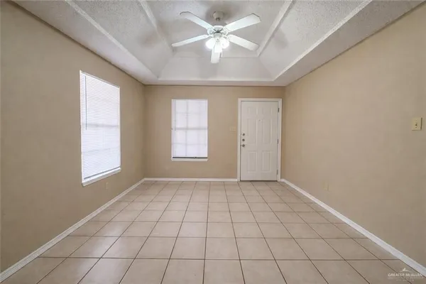 an empty room with windows and ceiling fan
