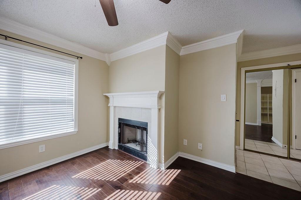 2200 East Trinity Mills Road, Unit 214 Carrollton, TX 75006 - Photo 13 of 25 a view of an empty room with wooden floor and a window
