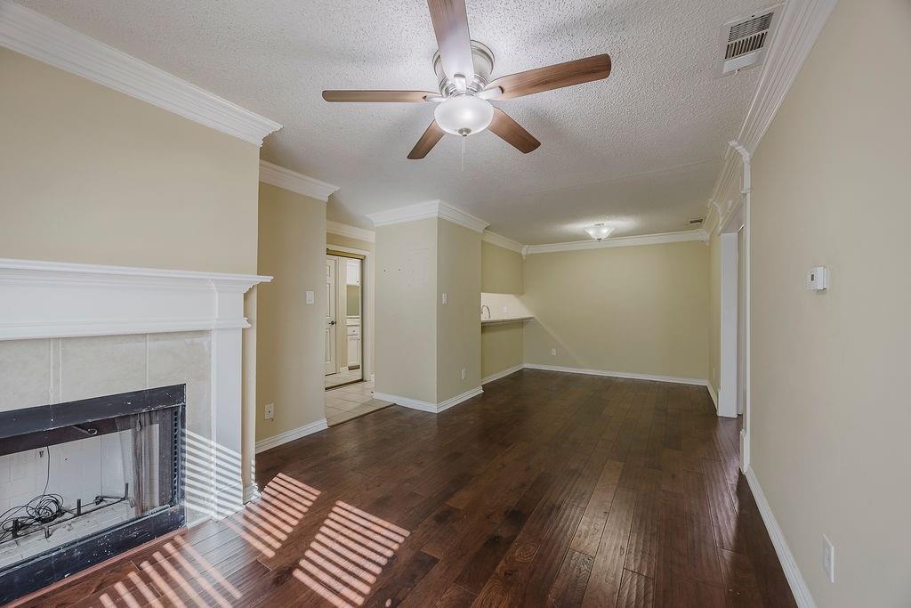 2200 East Trinity Mills Road, Unit 214 Carrollton, TX 75006 - Photo 14 of 25 a view of an empty room with wooden floor fireplace and a window