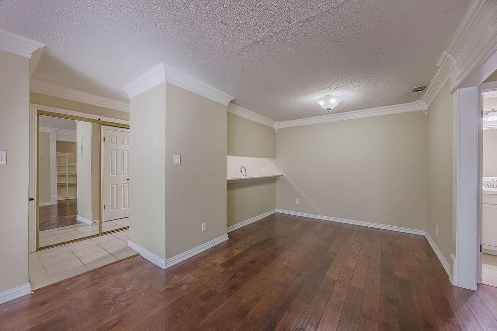 2200 East Trinity Mills Road, Unit 214 Carrollton, TX 75006 - Photo 16 of 25 a view of an empty room with wooden floor and closet