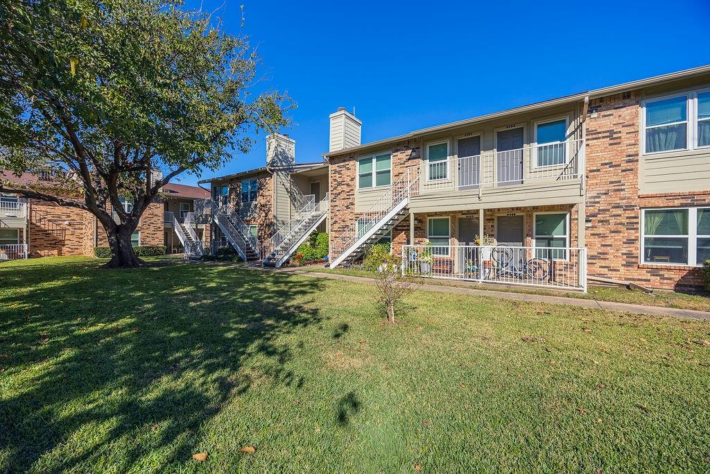 2200 East Trinity Mills Road, Unit 214 Carrollton, TX 75006 - Photo 5 of 25 a view of a house with a yard