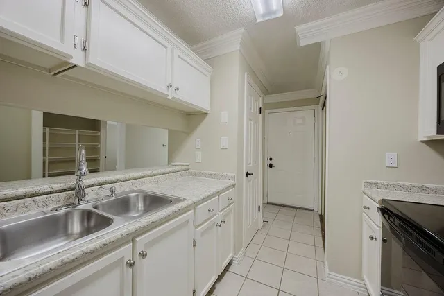 a kitchen with stainless steel appliances granite countertop white cabinets and black stove top oven with granite countertops