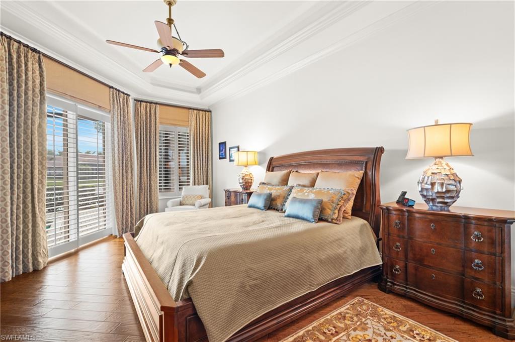 7833 Classics Drive Naples, FL 34113 - Photo 21 of 43 Bedroom with crown molding, ceiling fan, a raised ceiling, dark hardwood / wood-style flooring, and access to exterior