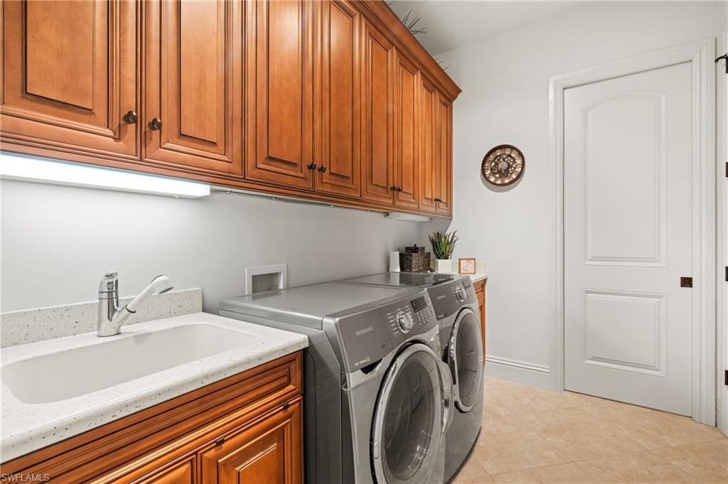 7833 Classics Drive Naples, FL 34113 - Photo 31 of 43 Clothes washing area featuring sink, light tile patterned flooring, cabinets, and washer and dryer