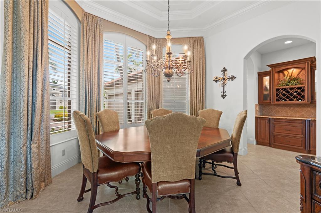 7833 Classics Drive Naples, FL 34113 - Photo 5 of 43 Dining space with a notable chandelier, a wealth of natural light, a raised ceiling, and crown molding