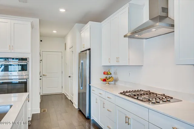 a kitchen with white cabinets and appliances
