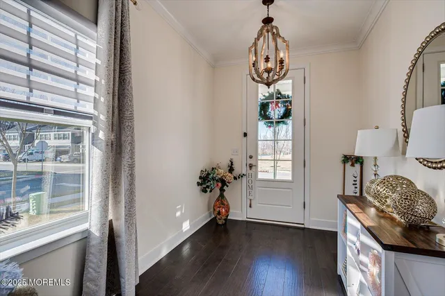 a room with wooden floor chandelier and windows