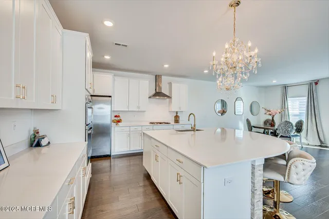 a large kitchen with kitchen island a sink counter space appliances and cabinets
