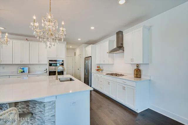a kitchen with kitchen island white cabinets and refrigerator
