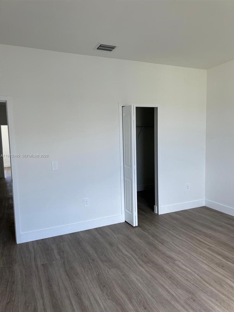 34430 Southwest 190th Avenue Homestead, FL 33034 - Photo 11 of 18 an empty room with wooden floor and closet
