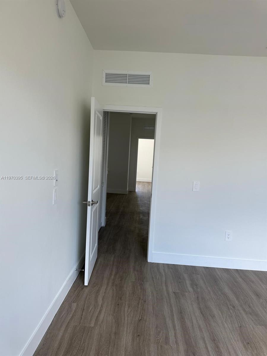 34430 Southwest 190th Avenue Homestead, FL 33034 - Photo 13 of 18 an empty room with wooden floor and closet