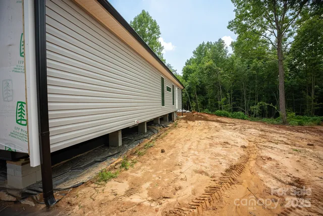 a view of backyard with wooden fence and large trees