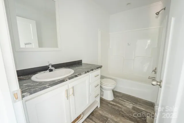 a kitchen with granite countertop a stove a sink and a refrigerator
