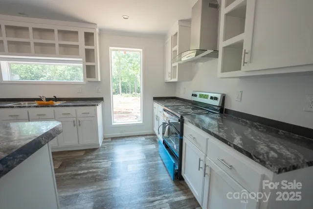 a kitchen with stainless steel appliances granite countertop a refrigerator a sink dishwasher a stove a refrigerator and microwave