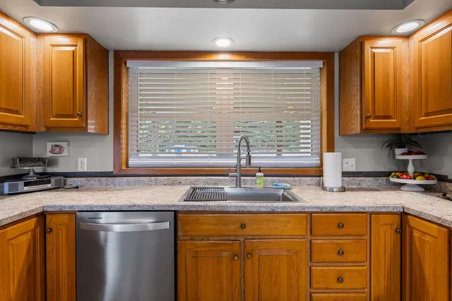 a kitchen with granite countertop cabinets sink and window
