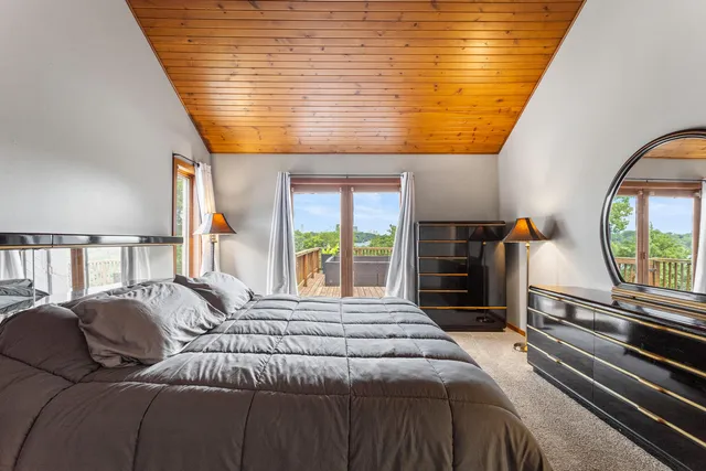 a bedroom with a large bed and a flat tv screen