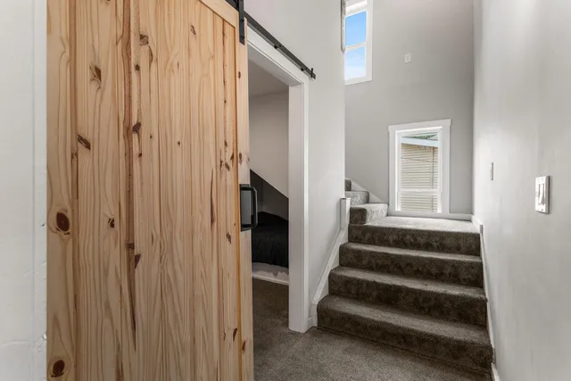 a view of staircase with lots of frames on wall