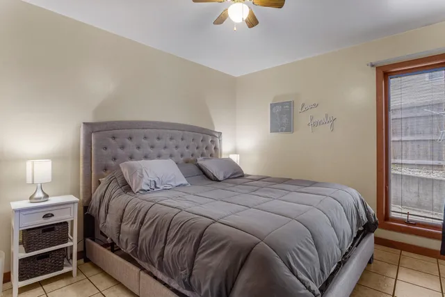 a bedroom with a bed and a lamp on dresser