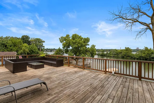 a view of a balcony with wooden floor and outdoor seating