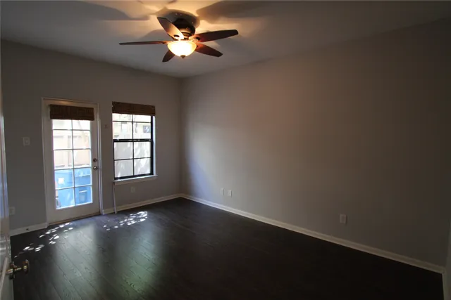 a view of wooden floor and a chandelier fan in a room
