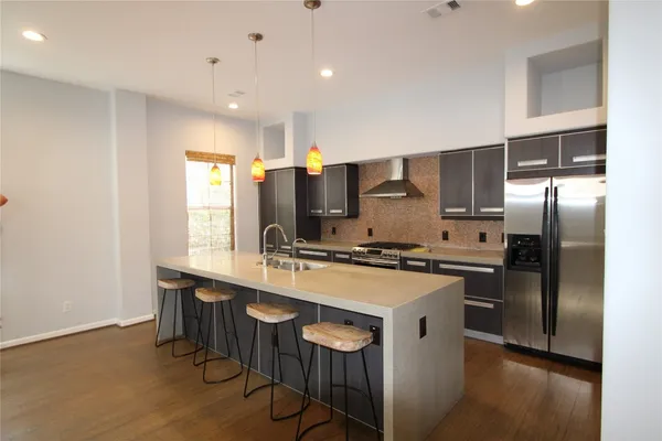 a kitchen with stainless steel appliances a sink a stove a refrigerator and cabinets