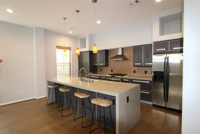 a kitchen with stainless steel appliances a sink a stove a refrigerator and cabinets