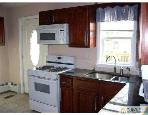 183 Old Post Road Edison, NJ 08817 - Photo 4 of 8 a kitchen with granite countertop a stove a sink and a microwave