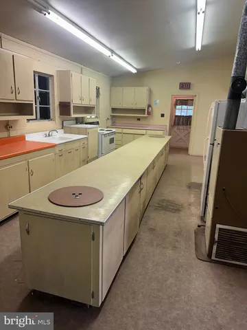 a large kitchen with stainless steel appliances kitchen island granite countertop a sink a stove top oven a granite counter space and cabinets