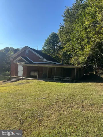 a front view of house with yard and trees in the background