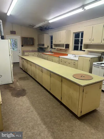 a kitchen with stainless steel appliances a stove a sink a refrigerator a microwave and cabinets