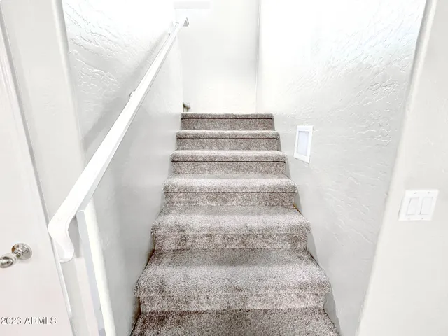 a view of a hallway with wooden floor and a bathroom