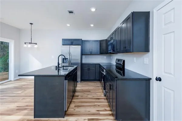 a kitchen with stainless steel appliances granite countertop a sink stove and cabinets