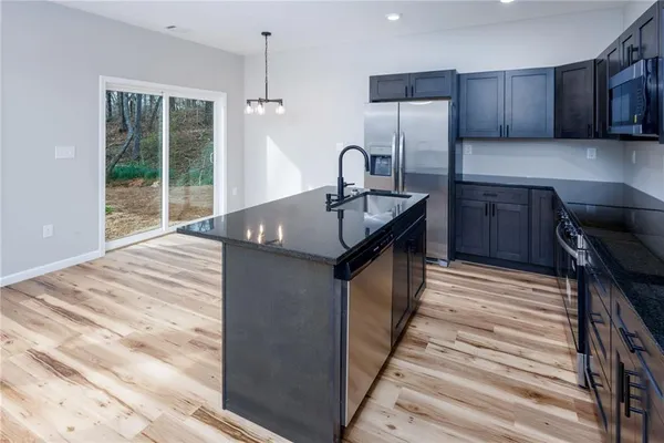 a kitchen with granite countertop sink cabinets and stainless steel appliances