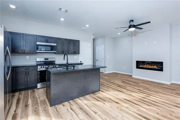 a kitchen with granite countertop wooden floors a sink and a stove